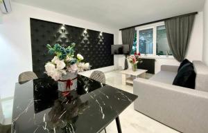 a living room with a table with flowers on it at Central Apartament Mangalia in Mangalia