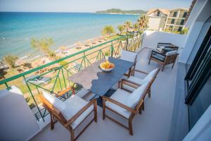 a balcony with a table and chairs and the ocean at YOLO Resort - Loft in Alykes