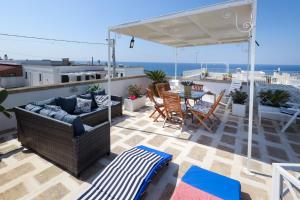 a patio with a couch and a table and chairs at Villetta mare Salento in Patù