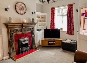 a living room with a fireplace and a television at Dog-Friendly Cottage, Skipton, Thisledo Holiday Cottage in Skipton