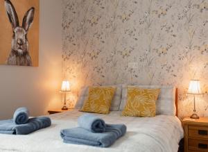 ein Schlafzimmer mit einem Bett mit blauen Handtüchern darauf in der Unterkunft Thisledo Holiday Cottage - Dog-friendly cosy cottage, 5 min walk to Skipton town centre in Skipton
