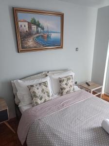 a bedroom with a bed with a painting on the wall at Historic Center Apartment at Thisseio in Athens