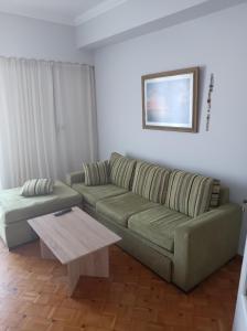 a living room with a green couch and a coffee table at Historic Center Apartment at Thisseio in Athens