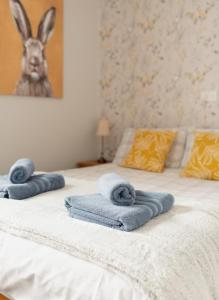 a bed with towels sitting on top of it at Thisledo Holiday Cottage, Woodman Terrace, Skipton - Pet Friendly in Skipton