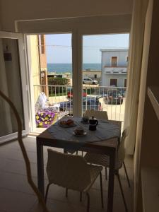 - une table sur un balcon avec vue sur l'océan dans l'établissement VIRGOLA ZERO HOLIDAY BEACH, à Porto Potenza Picena