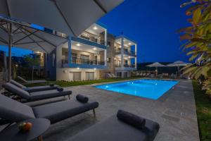 a large house with a swimming pool at night at Sea Wind Luxury Apartments with Pool Kassandra Halkidikι in Nea Fokea