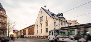 a bus driving down a street next to a building at Bob W Koti Katajanokka in Helsinki