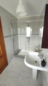 a white bathroom with a shower and a sink at Costa Da Morte in Vimianzo