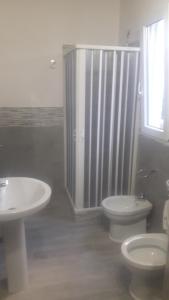 a bathroom with two sinks and a shower and a toilet at Appartamento Vincenzina in Lampedusa