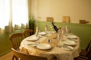 uma mesa longa com pratos e guardanapos em Le Balcon Bleu, gîte located in Millevaches National Park em Chavanac