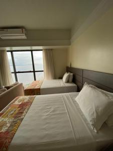 Postel nebo postele na pokoji v ubytování Tropical Executive Hotel