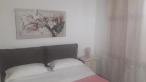 a bedroom with a bed and a picture on the wall at Appartamento Vincenzina in Lampedusa