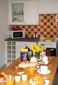 a kitchen with a table with breakfast food on it at Le Balcon Bleu, gîte located in Millevaches National Park in Chavanac