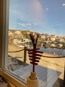 eine Vase auf einem Fensterbrett mit Blick auf einen Hafen in der Unterkunft Björkö SeaLodge in Björkö