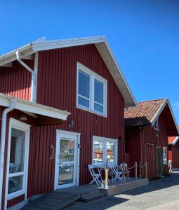 ein rotes Gebäude mit einem Tisch außerhalb des Gebäudes in der Unterkunft Björkö SeaLodge in Björkö