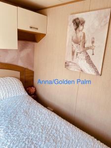 Golden Palm, 8 Berth Caravan في سكيجنيس: غرفة نوم مع لوحة لامرأة تمسك بزجاج النبيذ