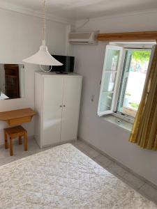 a kitchen with a white cabinet and a window at Filoxenia Kontogiannis in Lazaráta