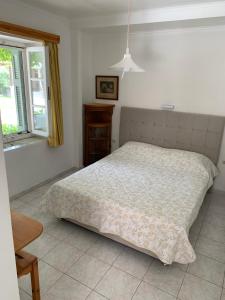 a bedroom with a bed and a window at Filoxenia Kontogiannis in Lazaráta