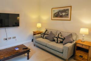 a living room with a couch and a table at Hedgefield House - Serene Top Floor Flat in Inverness