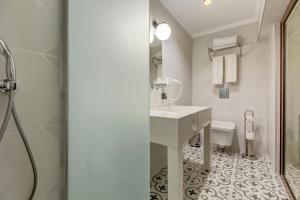 a white bathroom with a sink and a toilet at Baldan Suites in Bozburun