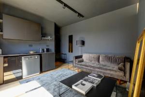 a living room with a couch and a kitchen at Appartement artiste atelier bail mobilité Palais Royal in Paris