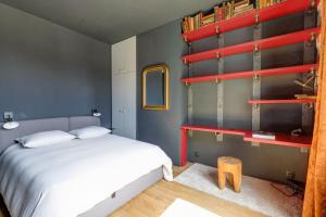 um quarto com uma cama branca e prateleiras vermelhas em Appartement artiste atelier bail mobilité Palais Royal em Paris