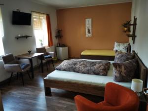 Penzion u Jezevce في هرينسكو: غرفة نوم بسرير وطاولة وكراسي