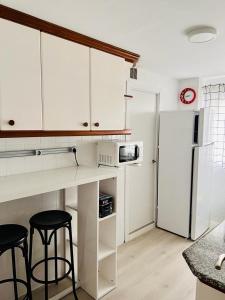 a kitchen with white cabinets and a white refrigerator at Viveiro-Lugomar in Viveiro