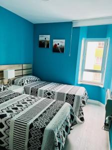 two beds in a room with blue walls at Viveiro-Lugomar in Viveiro