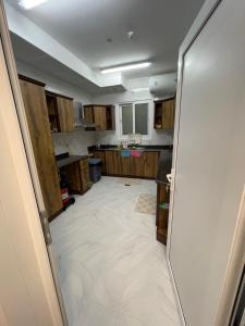 a kitchen with a large white tile floor at Yas Hotel Apartments in Al Ain