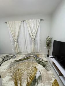 a living room with a large window and a rug at Yas Hotel Apartments in Al Ain