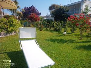a white bench in a yard with a ball at Casa de la Luna in Nettuno