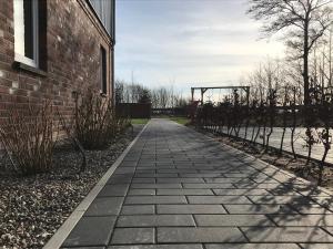 ニービュルにあるUrlaubswindのバスケットボール用フープ付きのレンガ造りの建物の横の歩道