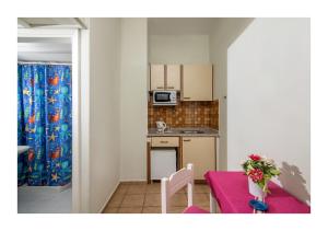 a small kitchen with a table with a purple table cloth at Malia Semiramis by Estia in Malia
