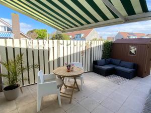 a patio with a table and chairs and a couch at Bed en Koffie Casa Mañana de Koog in De Koog