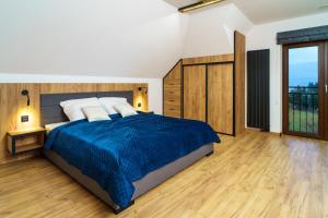 a bedroom with a large bed with a blue blanket at Apartament Blisko Słońca - Jacuzzi na wyłączność in Nowy Targ +33 photos