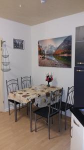 een eettafel met stoelen en een schilderij aan de muur bij FeWo am Schlosspark Putbus in Putbus