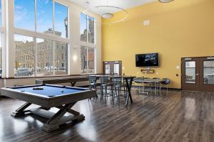 a billiard room with tables and a flat screen tv at Kasa Westown Milwaukee in Milwaukee