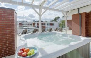 a hot tub on a balcony with a bowl of fruit at Apartament Klifowa Rewal 16 in Rewal