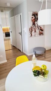 a white table with a bowl of fruit on it at Apartament Klifowa Rewal 16 in Rewal