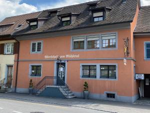 ein orangefarbenes Gebäude mit einer Treppe davor in der Unterkunft Garni-Hotel Mühletal in Stein am Rhein