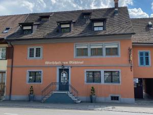 ein orangefarbenes Gebäude mit einer Treppe davor in der Unterkunft Garni-Hotel Mühletal in Stein am Rhein