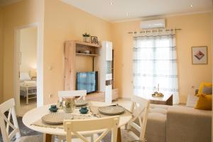 a dining room and living room with a table and chairs at Aurelia Seaside Apartment in Kavos