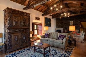 Quinta de Mourães - Casa do Xisto في Lever: غرفة معيشة مع أريكة وخزانة خشبية كبيرة