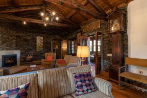 sala de estar con muebles y pared de piedra. en Quinta de Mourães - Casa do Xisto en Lever