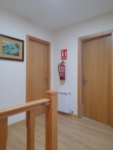a room with a door and a fire extinguisher on the wall at SLEEPING PORTOMARIN 2 in Portomarin