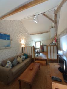 a living room with a couch and a table at ecurie le buguet in Saint-Antoine-Cumond