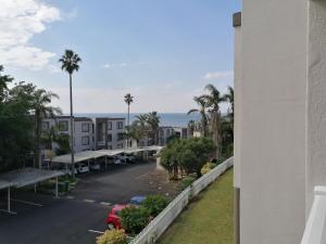 een uitzicht vanaf het balkon van een gebouw met een parkeerplaats bij Laguna la crete 169 uvongo in Margate