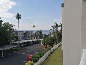 a view from the balcony of a building with a parking lot at Laguna la crete 169 uvongo in Margate