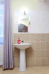 ein Bad mit einem Waschbecken und einem Spiegel in der Unterkunft SERENE 4 BEDROOMED HOME IDEAL FOR FAMILY HOLIDAY in Mombasa